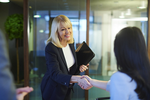 public administration professional smiling and shaking hands with a colleague