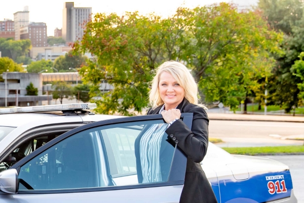 A white woman police officer opening her car door