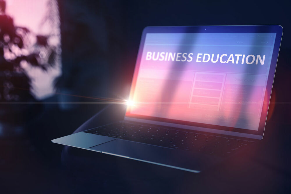 laptop open with a screen showing the words "business education"