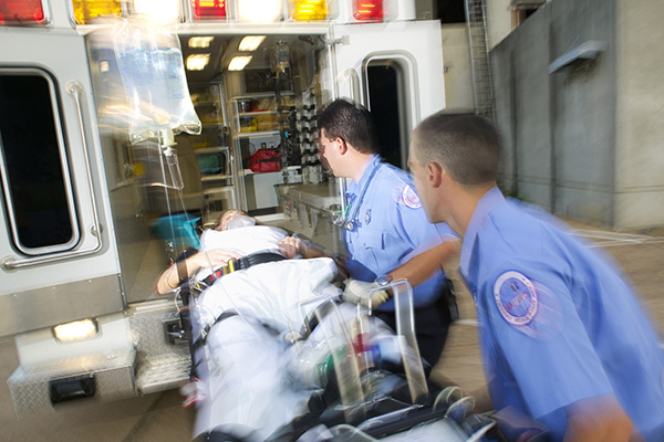 EMTs and paramedics transporting a patient onto an ambulance