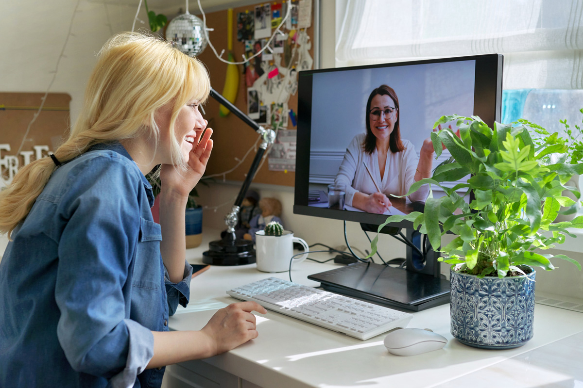 Psychologist and their client talking to each other during a telehealth session on a computer