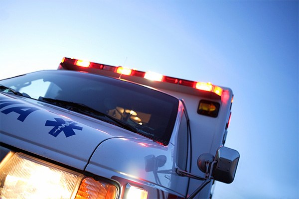 Close up of the front of an ambulance with lights on.