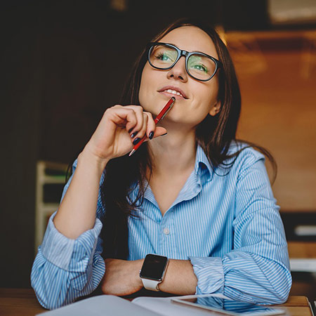 Student looks deep in thought while resting pen against chin