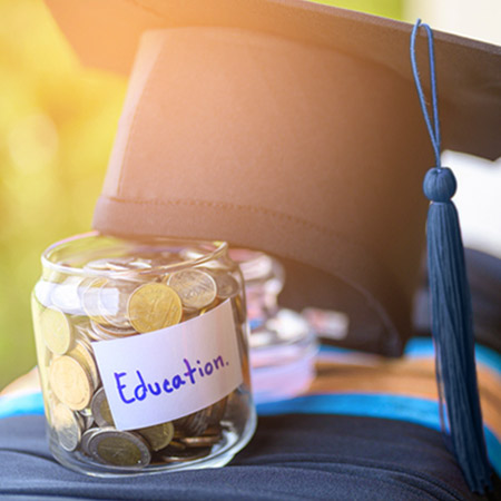 Jar labeled "Education" with graduation cap leaning against it