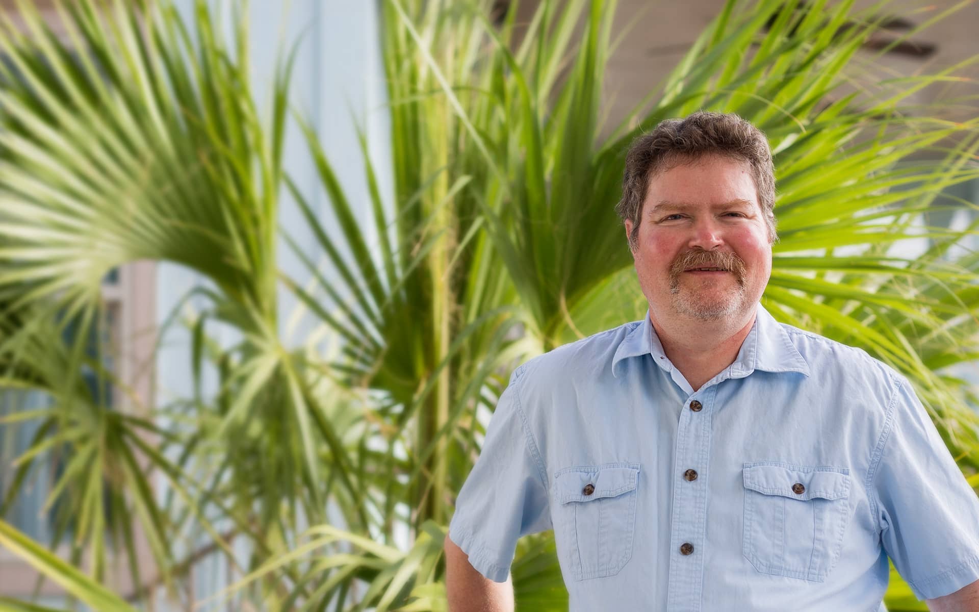 A close up of an older white man in a blue shirt