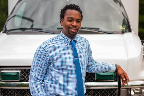 LeRon Lewis smiles as he leans against an ambulance.