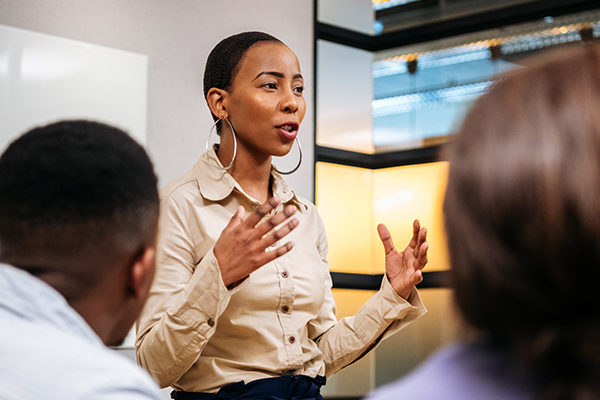 human resources professional standing in front of group and speaking while gesturing with hands