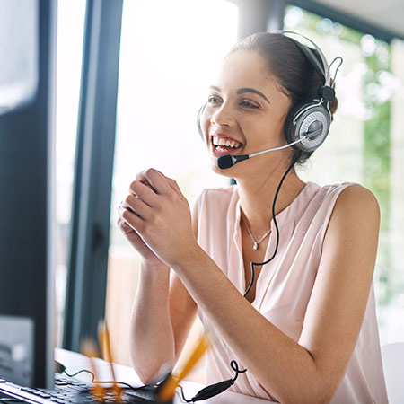 A cheerful student advisor wearing a headset smiles as she talks