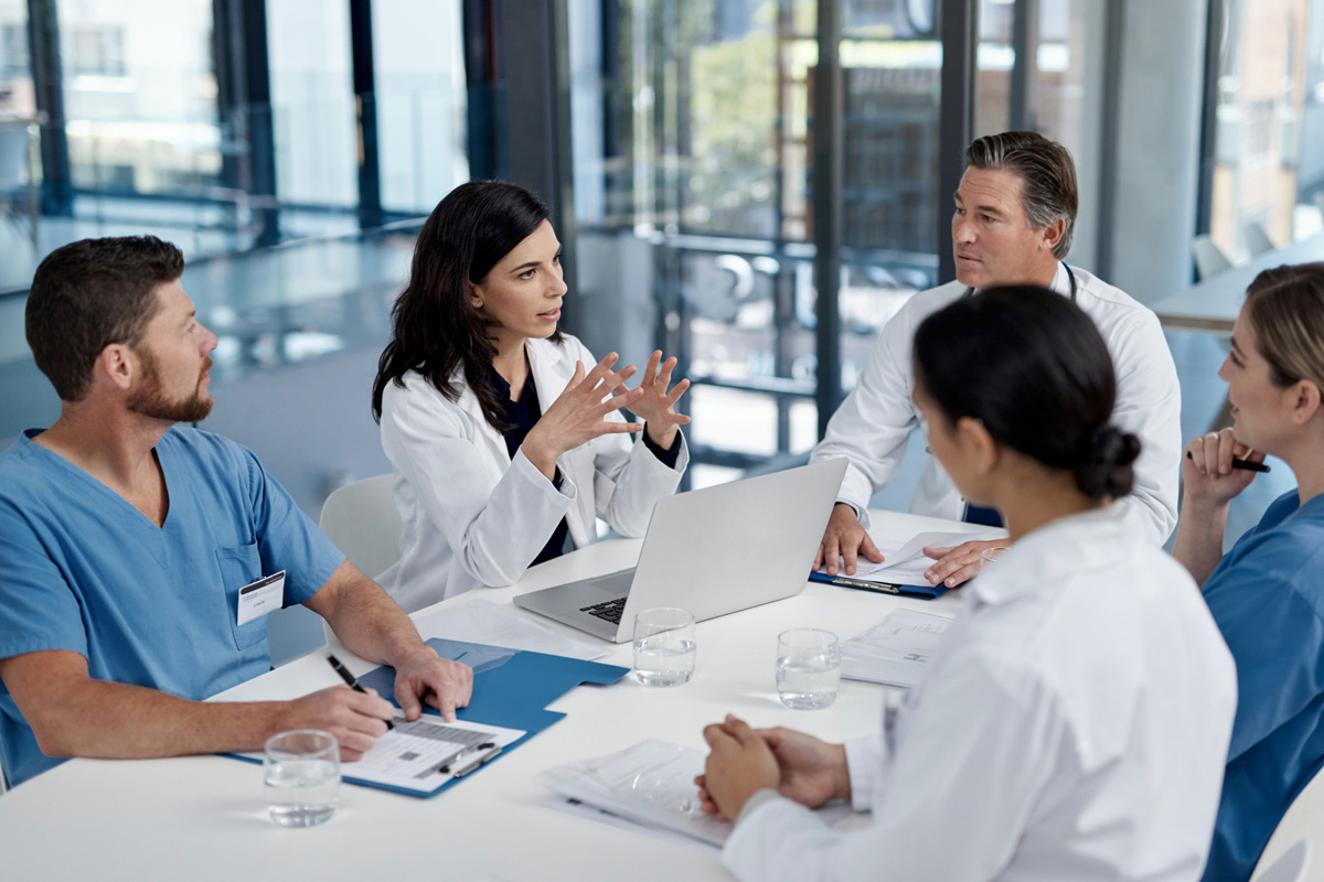 Healthcare professionals sitting at a table during a meeting and discussing emergency preparedness