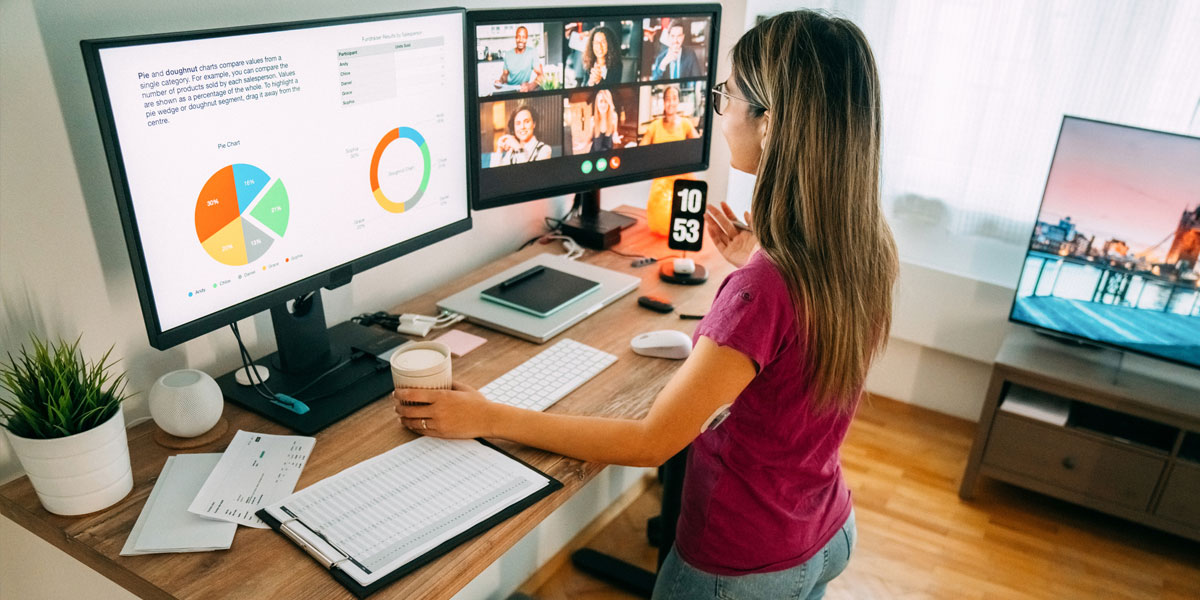 worker at a standing desk in their home office attending a virtual meeting on their computer