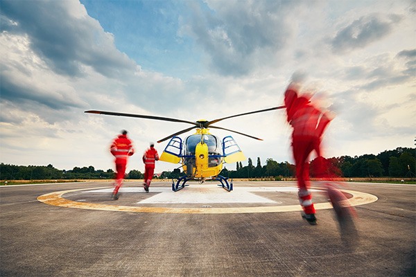 Blurred figures run toward a helicopter.