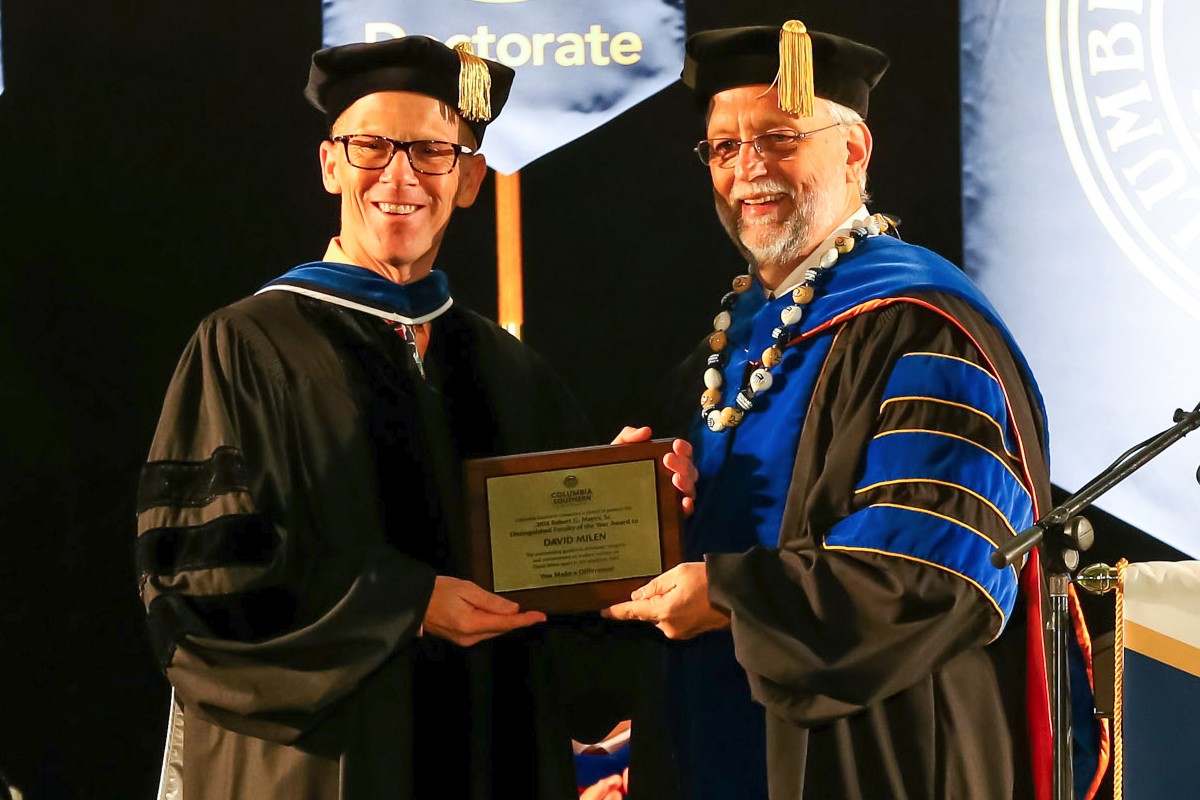 David Milen smiles as he accepts an award from CSU.