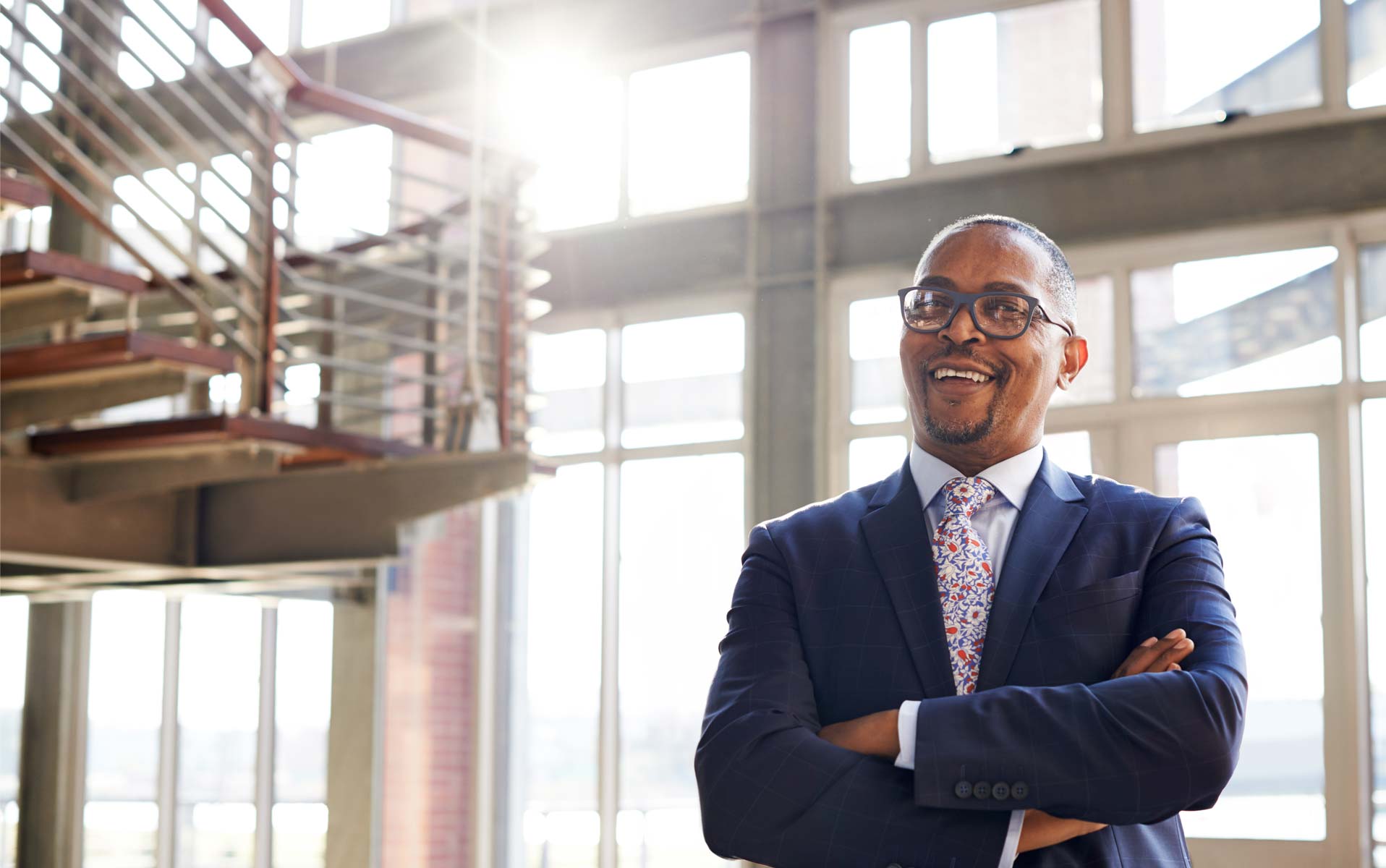 Business professional smiles with arms crossed