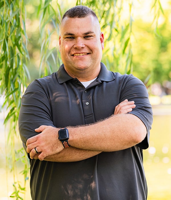 Photo of Royea standing with arms crossed