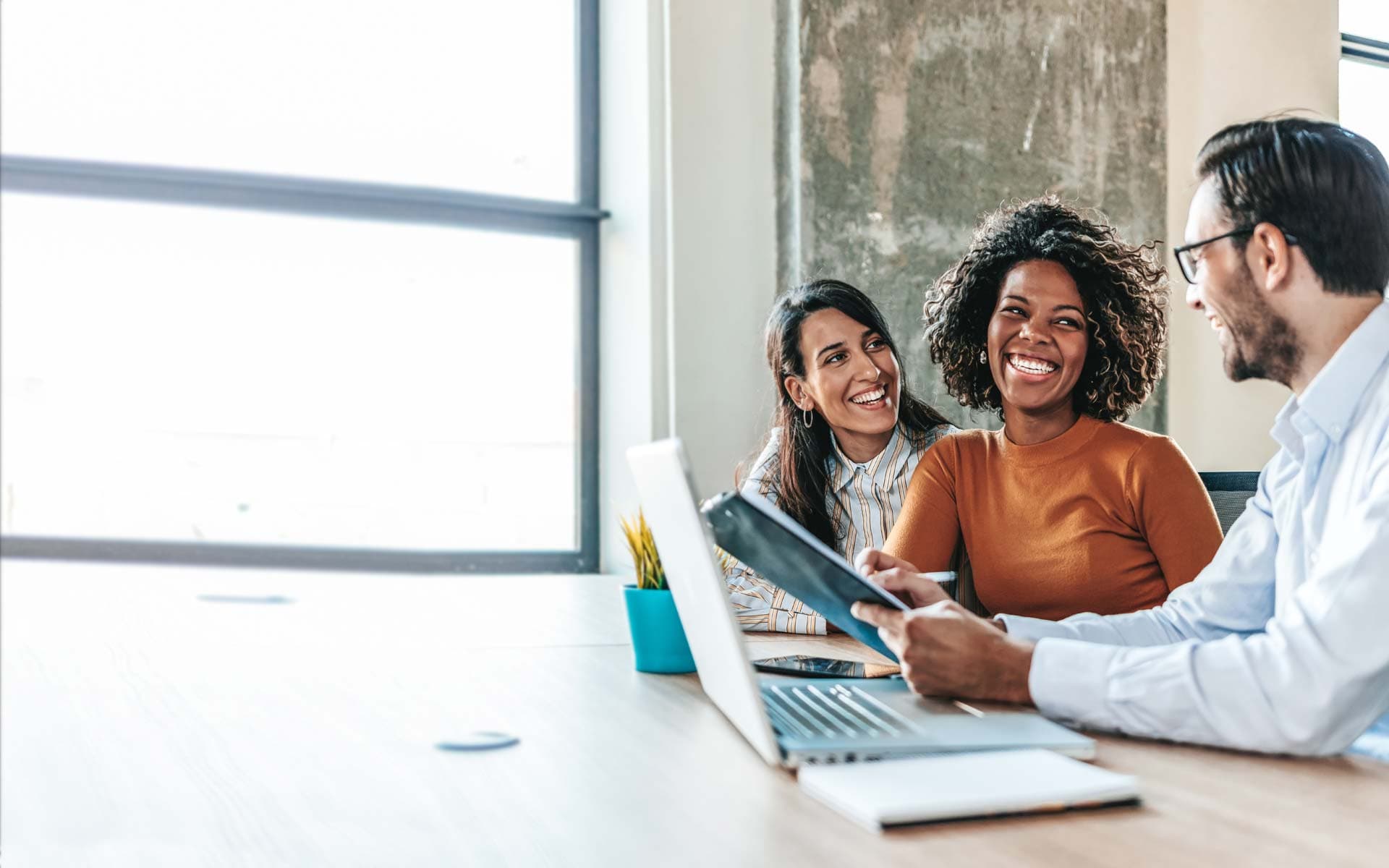 Group of co-workers smiling at each other and talking business