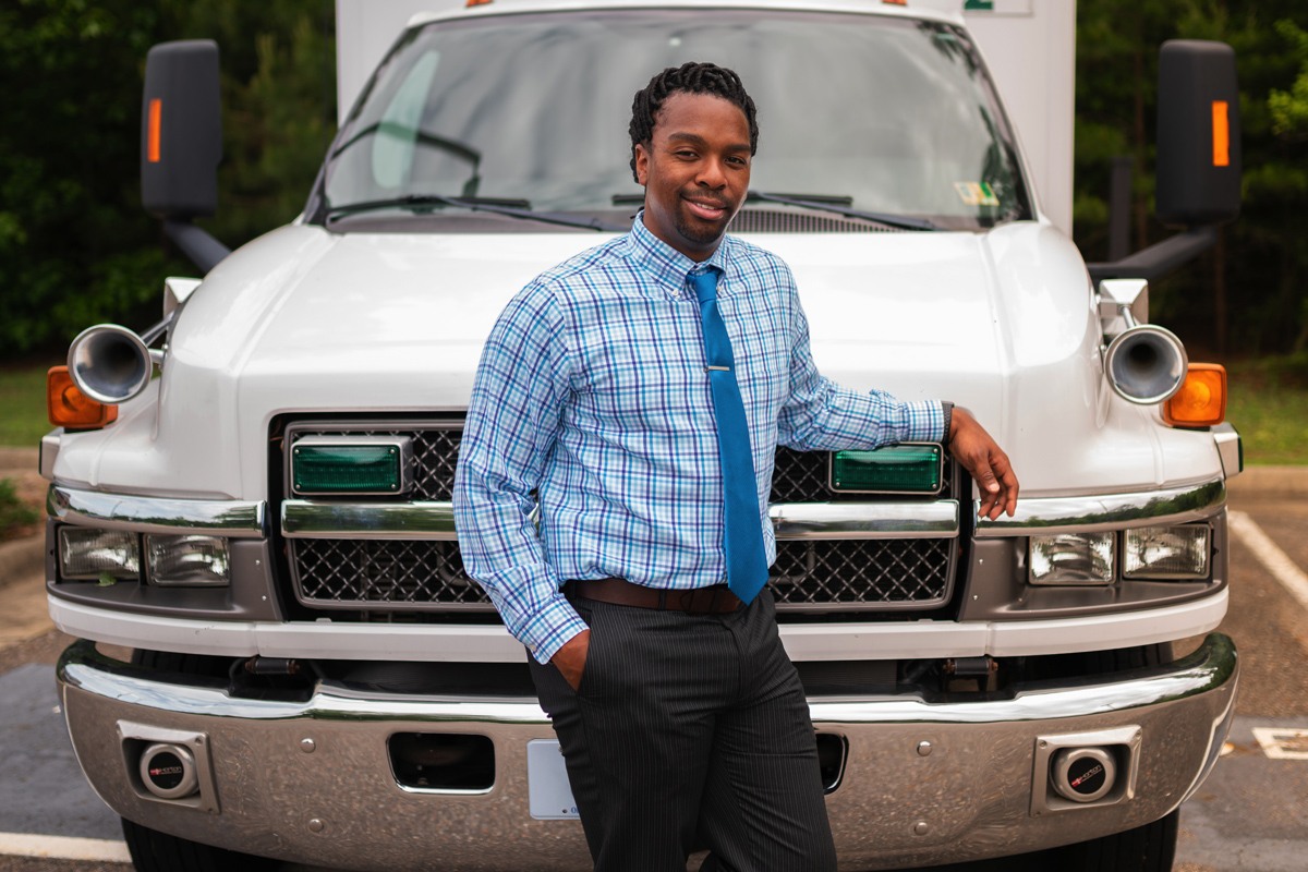 LeRon Lewis smiles as he leans against an ambulance.