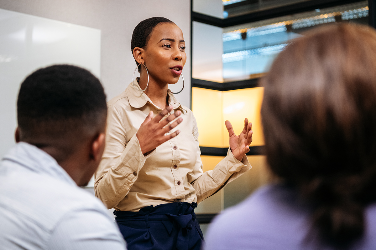 human resources professional standing in front of group and speaking while gesturing with hands