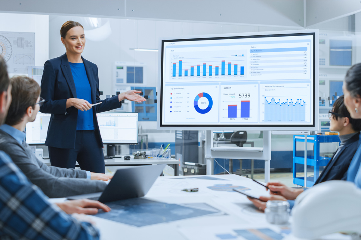 public administration professional presenting data on a screen to colleagues sitting around a conference room table