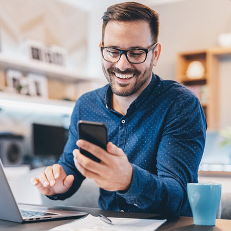 Student smiles and looks at phone