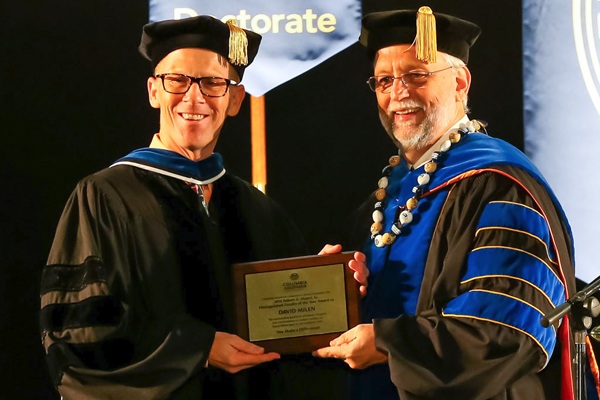 David Milen smiles as he accepts an award from CSU.