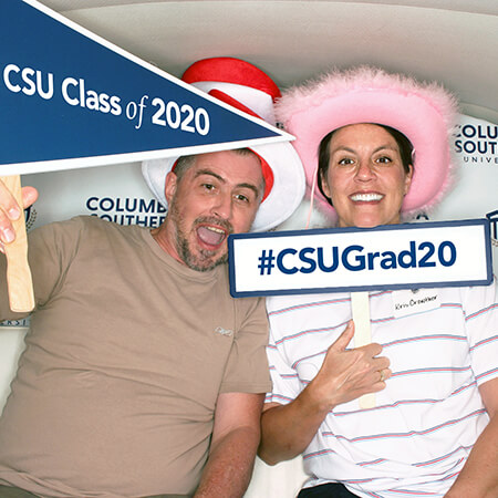 Graduates with props getting picture taken in photo booth