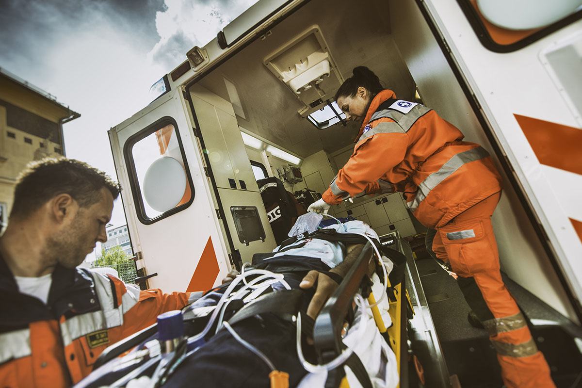 Two EMTs load a patient into an ambulance.