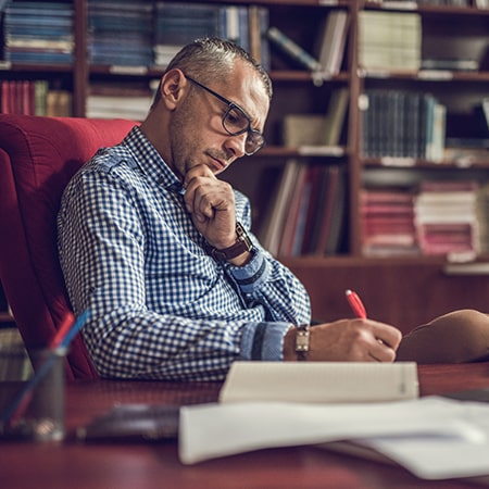 man thinking and writing