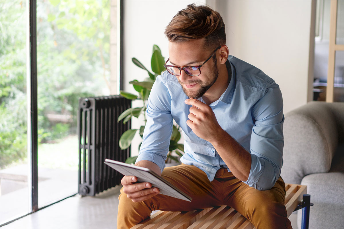 Seated student looking at tablet while considering transferring colleges