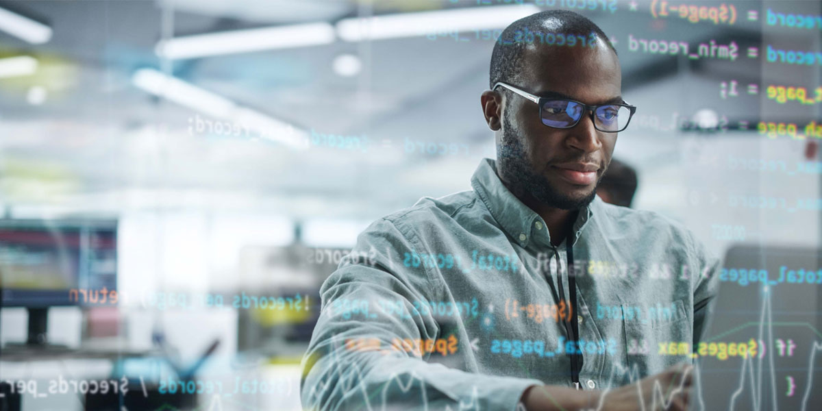 information technology professional sitting and working on a laptop