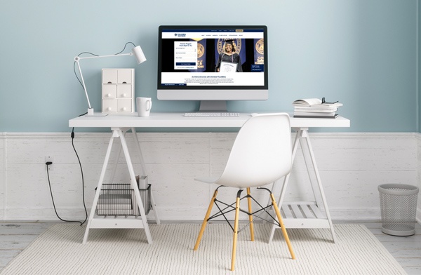 A home office desk with a computer showing the CSU homepage.