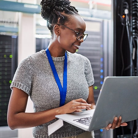 Young woman with laptop in hand checking on servers issues