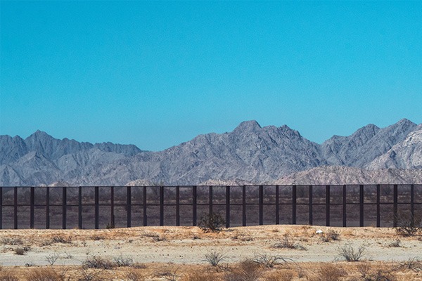 Border wall dividing USA and Mexico.
