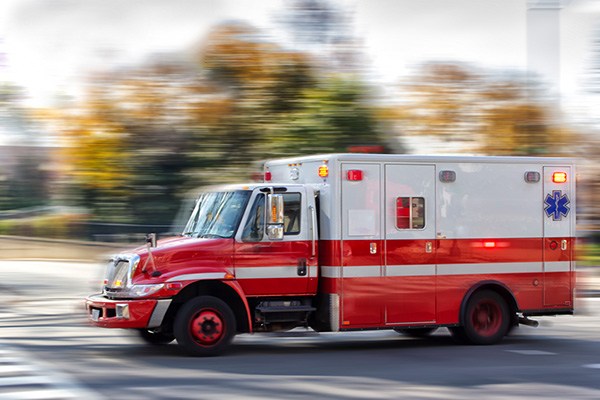 Ambulance speeds past blurred background