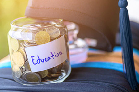 Jar of coins labelled "Education" with graduation cap resting against it